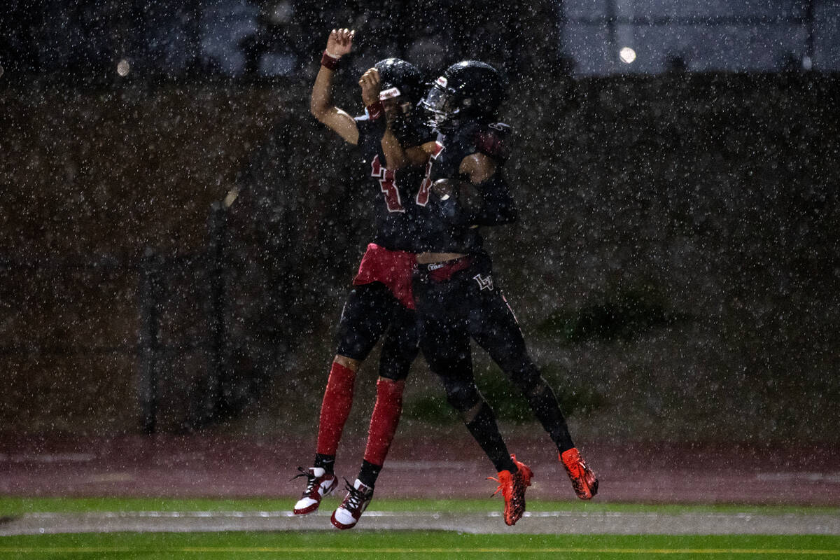 Las Vegas quarterback Tanner Vibabul (3) and cornerback Treshawn Bush (5) celebrate a touchdown ...