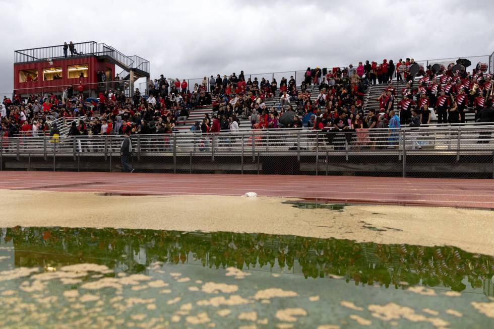 Las Vegas fans brave the rain for a high school football game against Rancho at Las Vegas High ...
