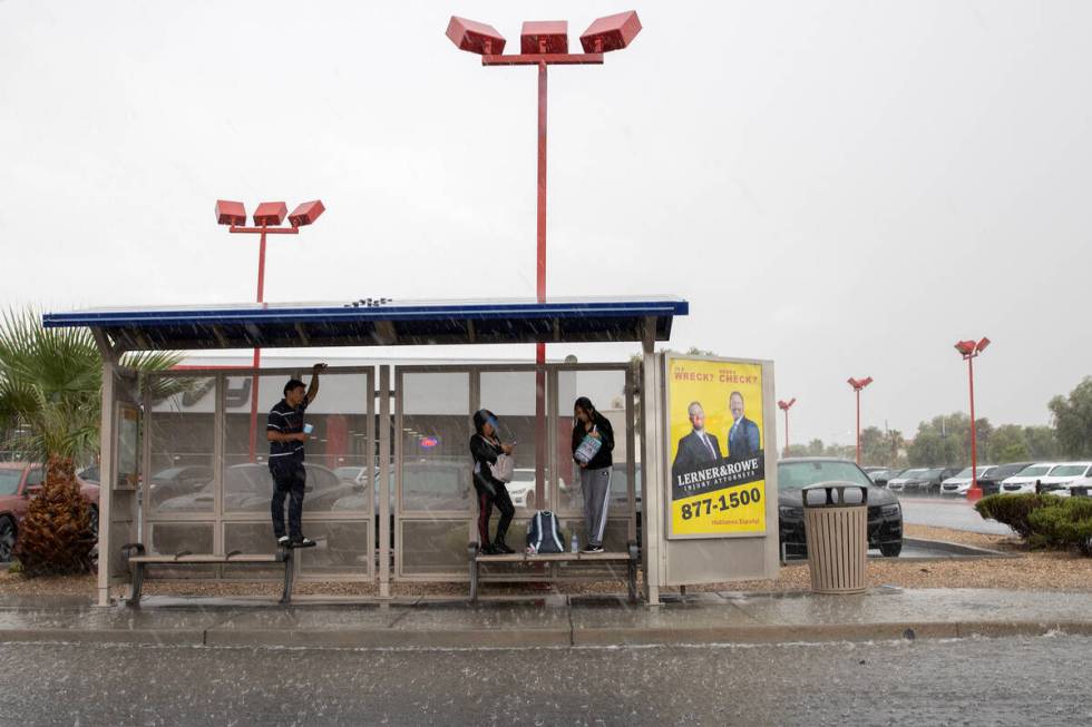 People shield themselves from rain in a bus shelter on East Sahara Avenue on Friday, Sept. 1, 2 ...