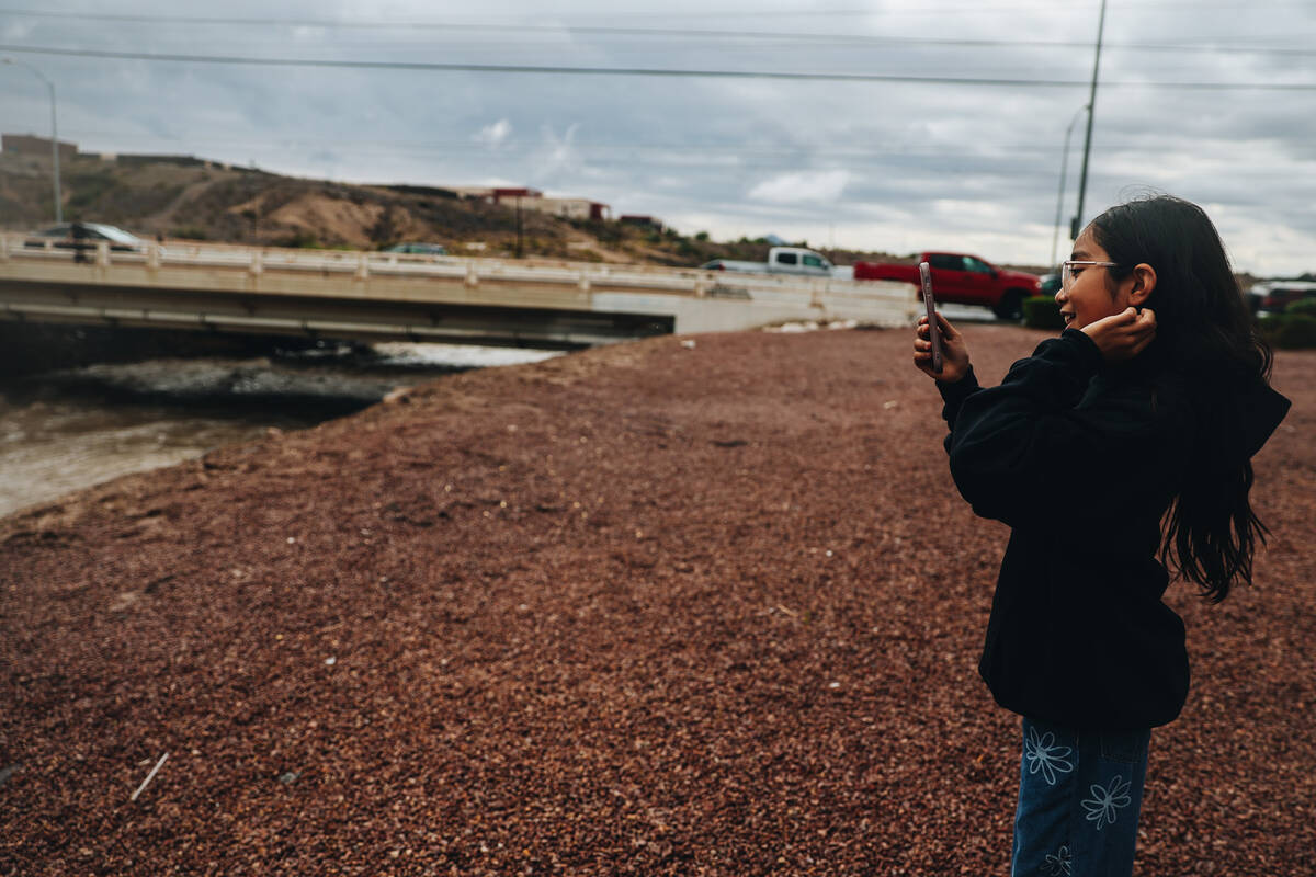 Aryanna Calvillo, 10, films water as it rushes through Duck Creek from recent rainfall near Jac ...