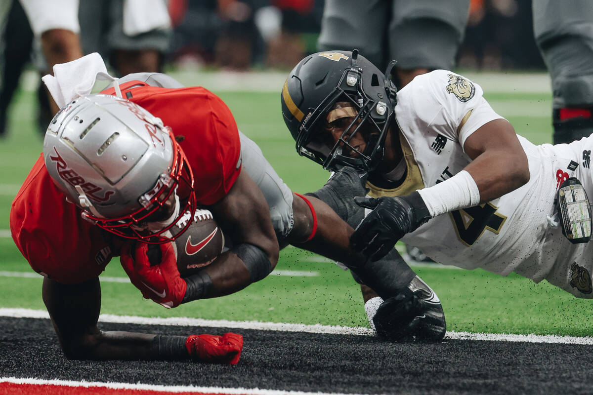 UNLV running back Jai’Den Thomas (22) makes it into the end zone for a touchdown as Brya ...