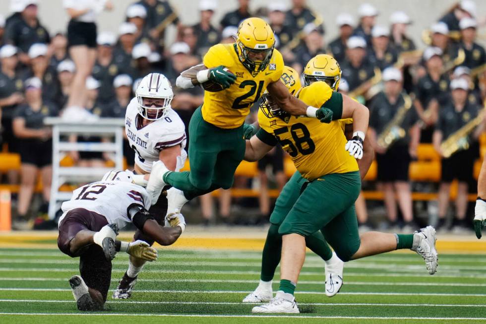 Baylor running back Dominic Richardson leaps over Texas State safety Tory Spears in the first h ...