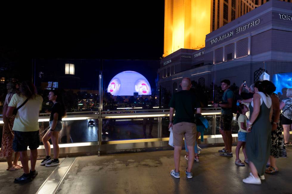 Visitors to the Las Vegas Strip view The Sphere on the pedestrian bridge over Sands Avenue betw ...