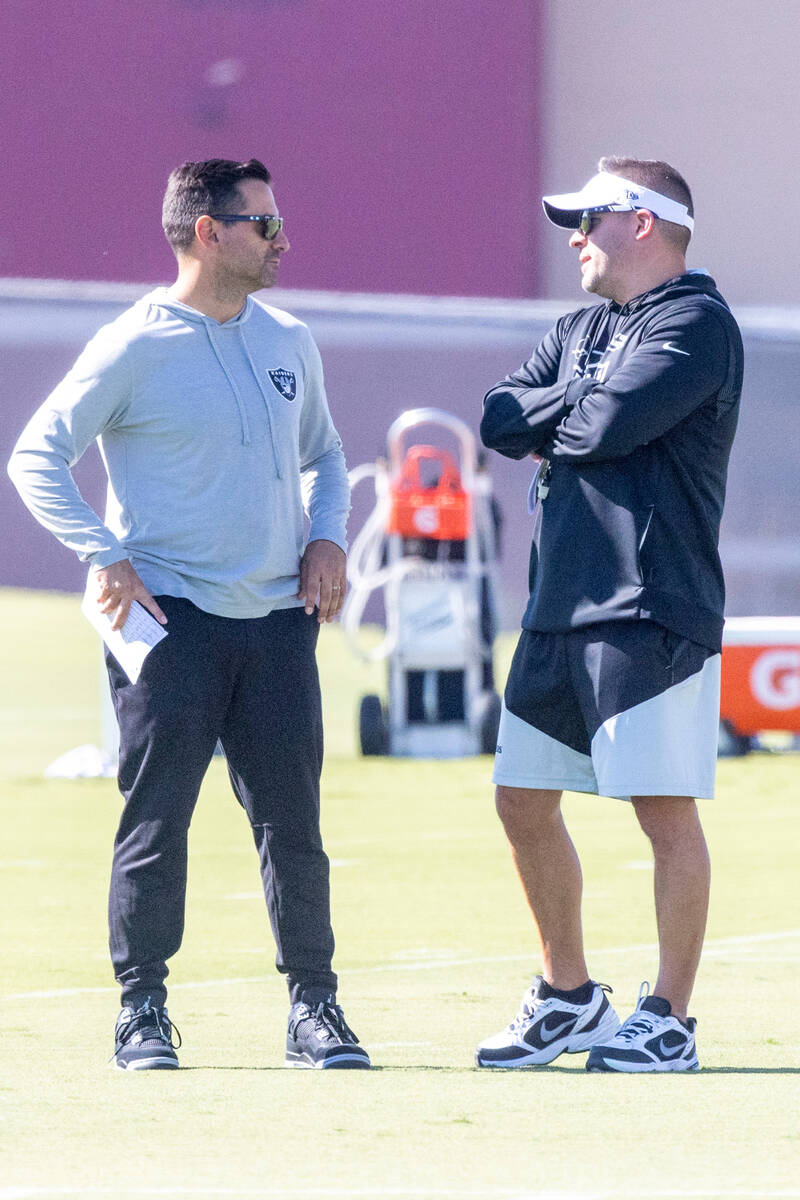 Raiders general manager Dave Ziegler, left, and head coach Josh McDaniels meet during practice ...