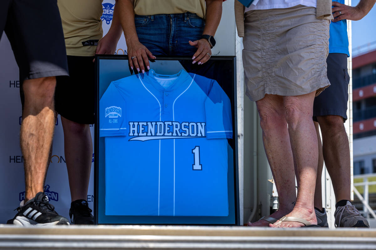 Mayor Michelle Romero holds her gifted uniform as the Henderson Little League team and coaches ...