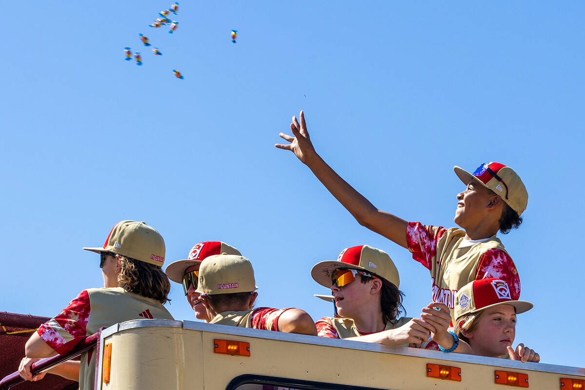 Henderson Little League team player JoJo Dixon (14) tosses bubblegum to fans as the team and co ...