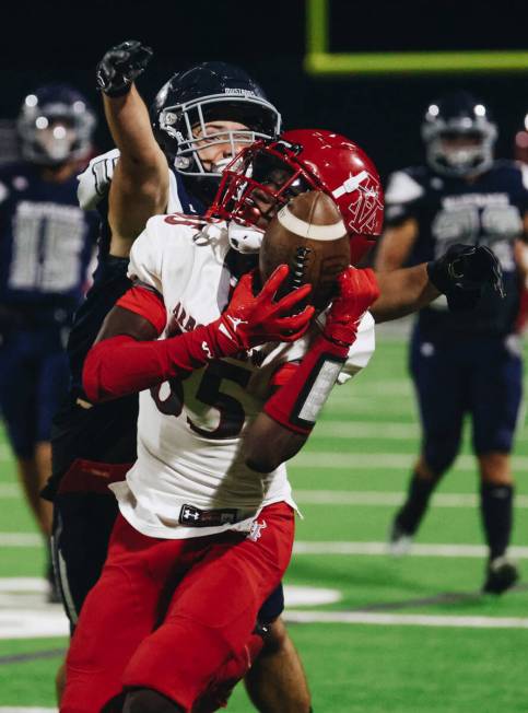 Shadow Ridge cornerback Tanner McDonald (10) grabs onto Arbor View wide receiver Mekhi Mitchell ...