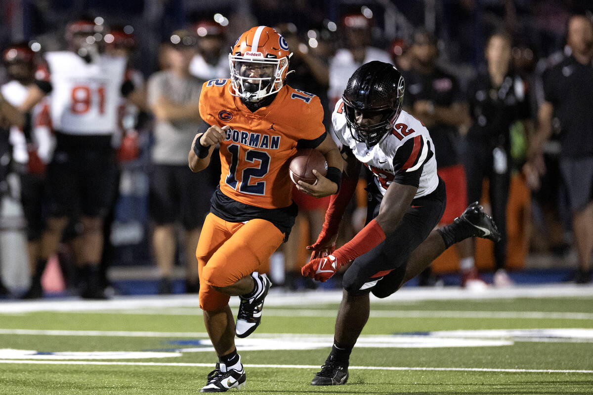 Bishop Gorman quarterback Micah Alejado (12) runs the ball while just out of grasp of Centennia ...