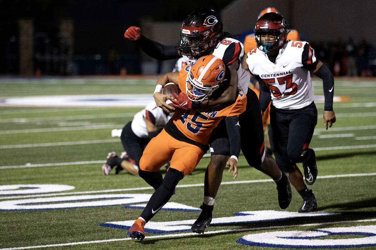 Bishop Gorman quarterback Melvin Spicer IV (15) runs through an attempted tackle by Centennial ...