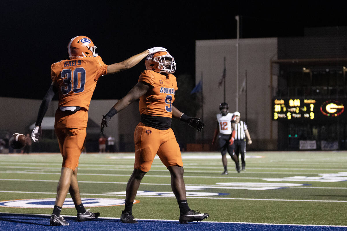 Bishop Gorman wide receiver Derek Meadows (30) congratulates his teammate Elija Lofton (9) on h ...