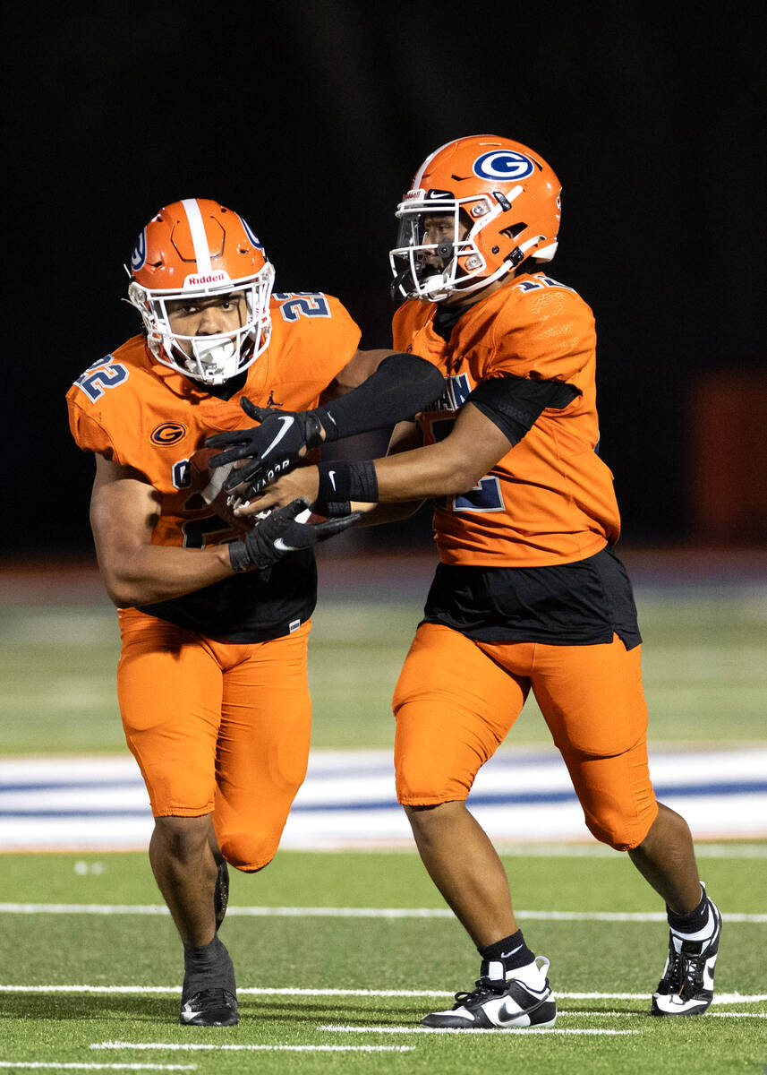 Bishop Gorman quarterback Micah Alejado (12) hands the ball off to running back Micah Kaapana ( ...