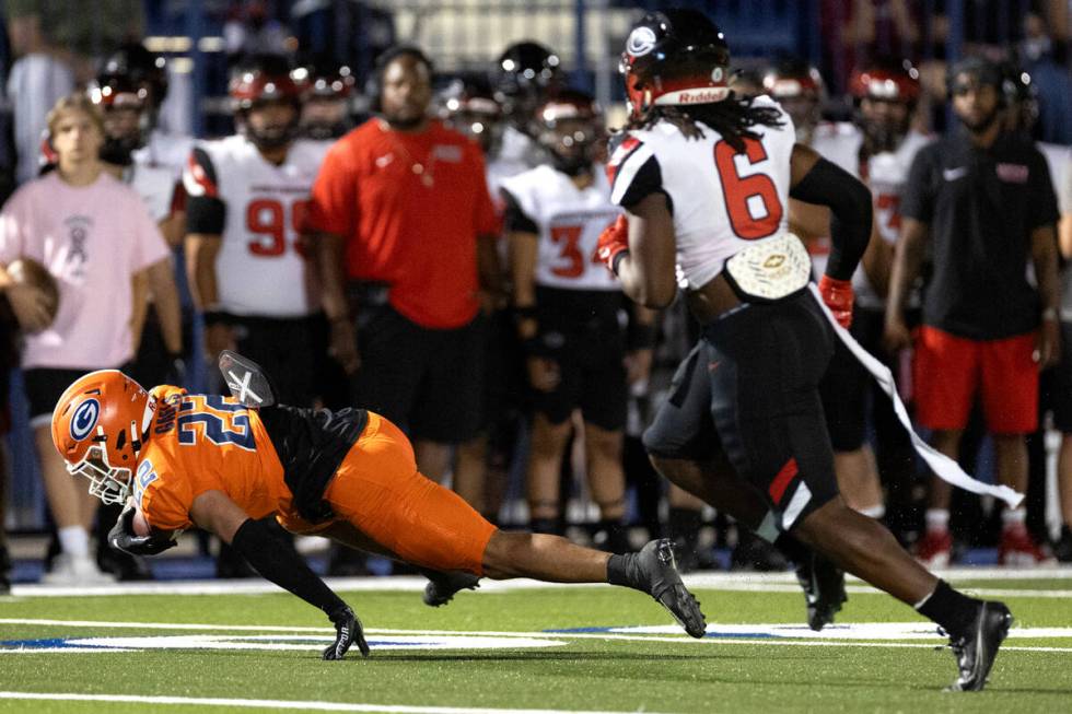 Bishop Gorman running back Micah Kaapana (22) dives through Centennial linebacker Syncere Brack ...