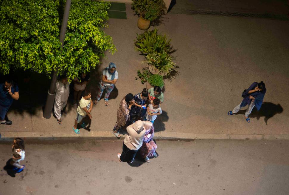 People take shelter and check for news on their mobile phones after an earthquake in Rabat, Mor ...