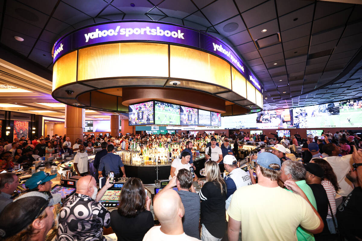 A crowd gathers as actor Mark Wahlberg pours some drinks at the grand opening of Yahoo Sportsbo ...