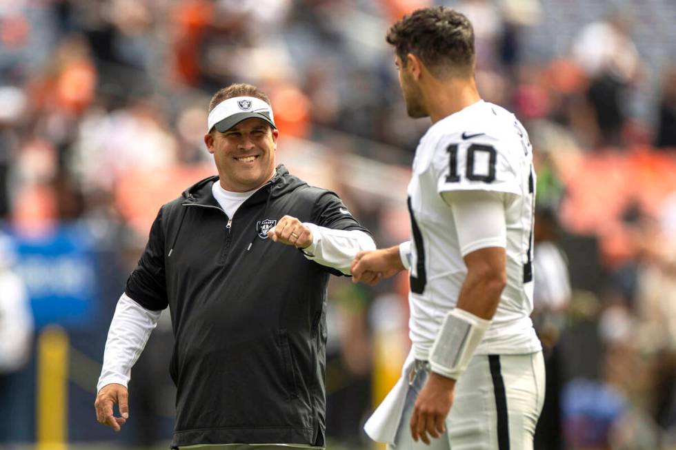 Raiders head coach Josh McDaniels meets with quarterback Jimmy Garoppolo (10) before the start ...