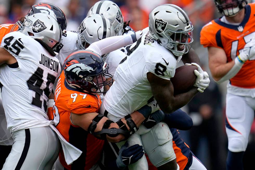 Las Vegas Raiders running back Josh Jacobs (8) is hit by Denver Broncos defensive end Zach Alle ...