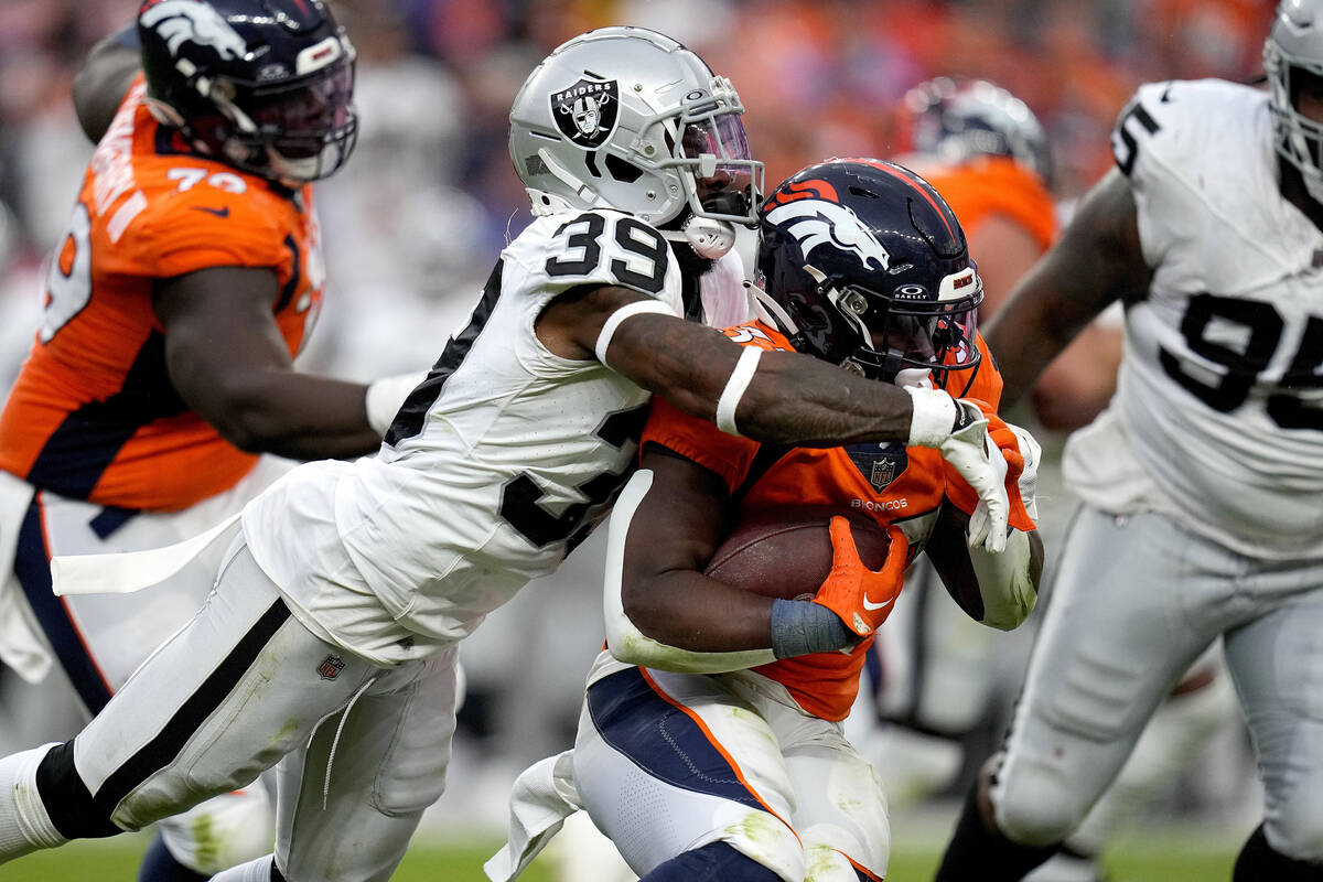 Las Vegas Raiders cornerback Nate Hobbs (39) tackles Denver Broncos running back Javonte Willia ...