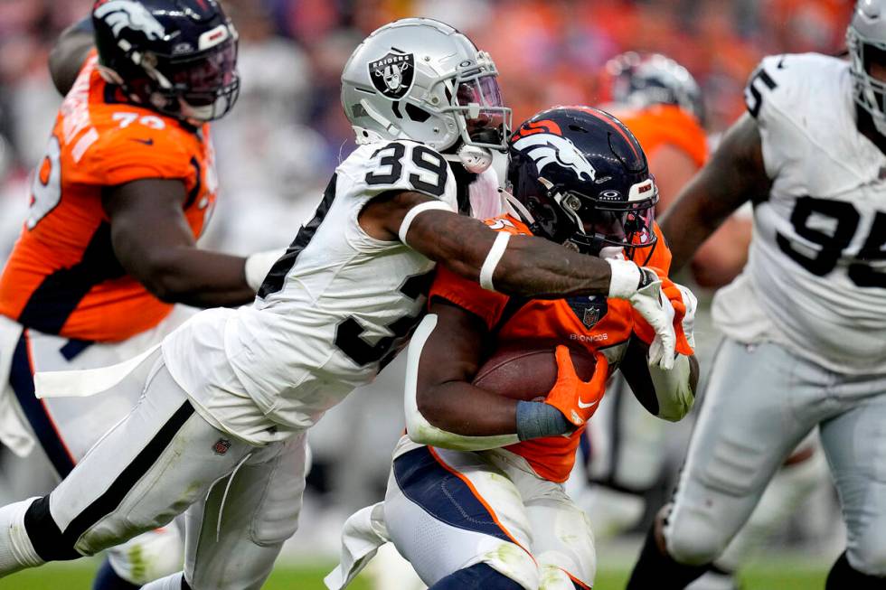 Las Vegas Raiders cornerback Nate Hobbs (39) tackles Denver Broncos running back Javonte Willia ...