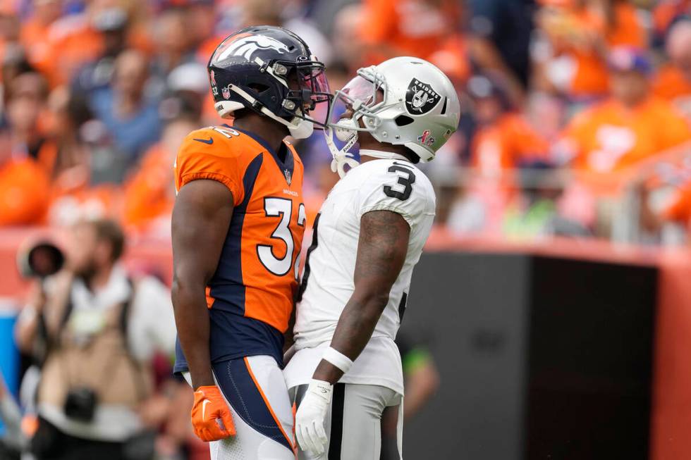 Denver Broncos safety Delarrin Turner-Yell, left, and Las Vegas Raiders wide receiver DeAndre C ...