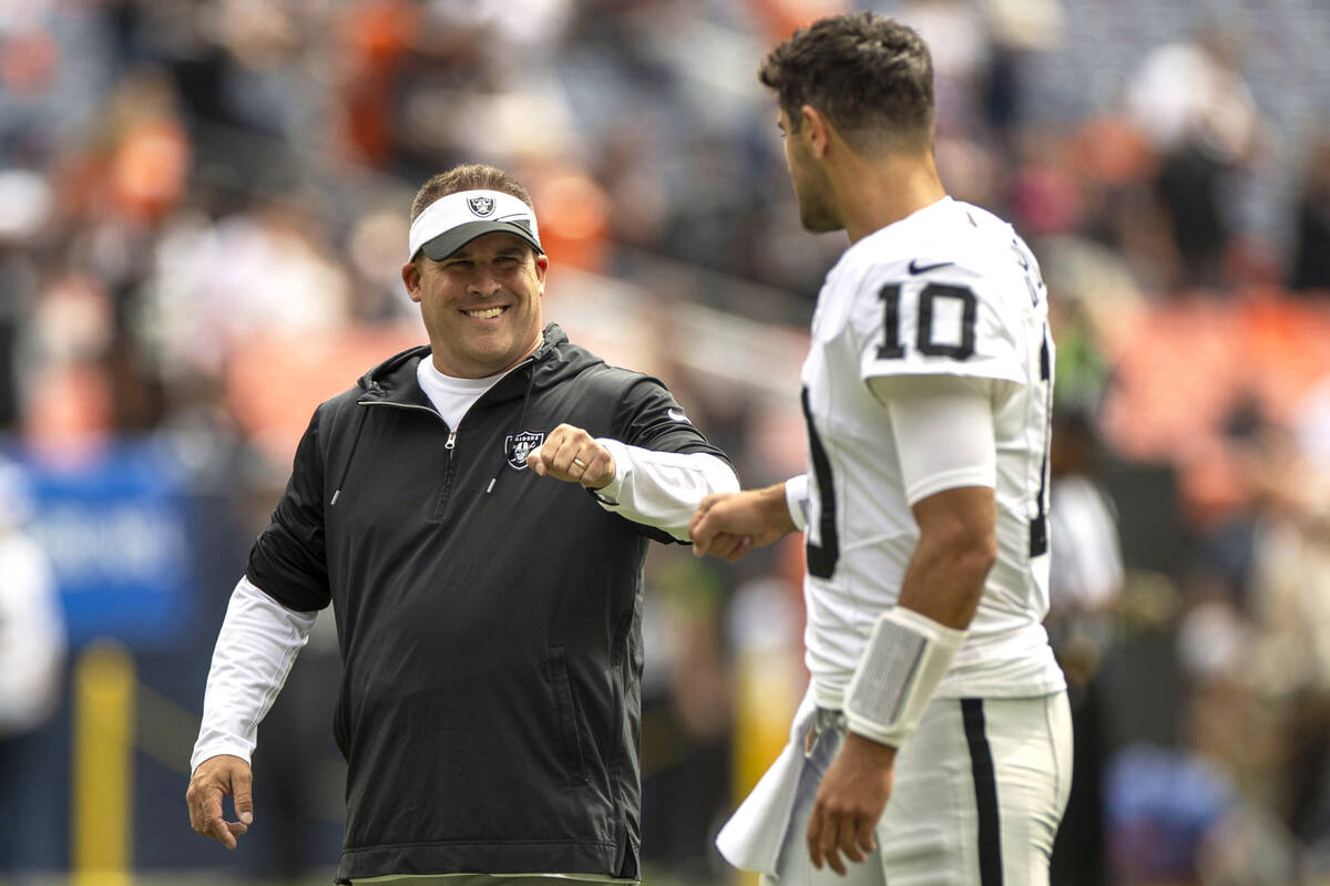 Raiders head coach Josh McDaniels meets with quarterback Jimmy Garoppolo (10) before the start ...