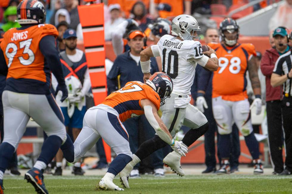 Raiders quarterback Jimmy Garoppolo (10) escapes a tackle by Denver Broncos linebacker Josey Je ...