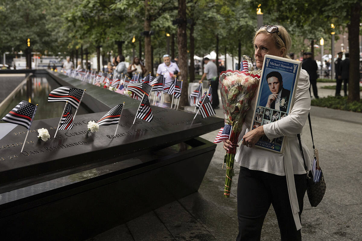 Diane Massaroli holds a picture of her late husband, Michael Massaroli, before the commemoratio ...