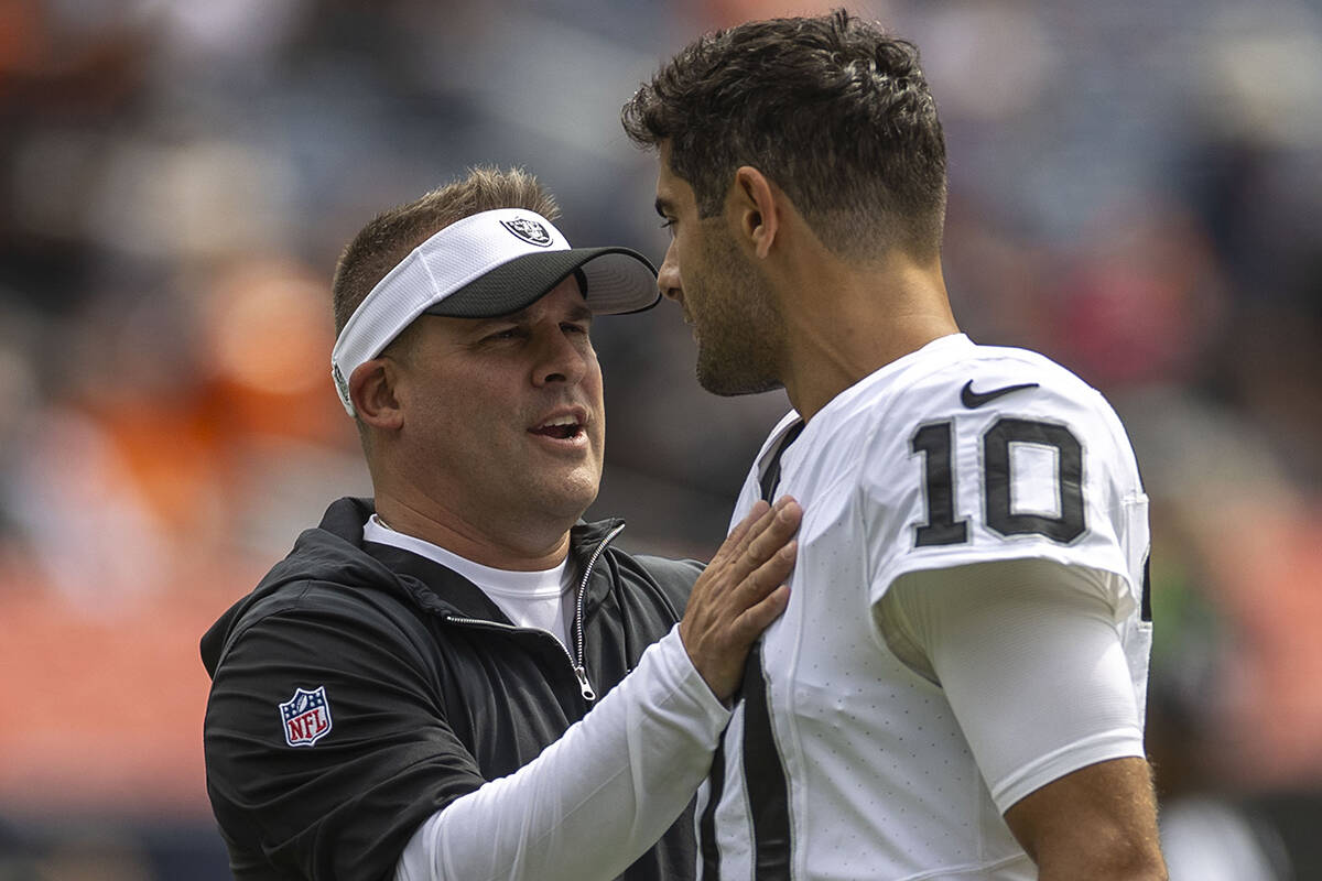 Raiders head coach Josh McDaniels meets with quarterback Jimmy Garoppolo (10) before the start ...