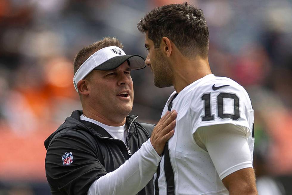 Raiders head coach Josh McDaniels meets with quarterback Jimmy Garoppolo (10) before the start ...