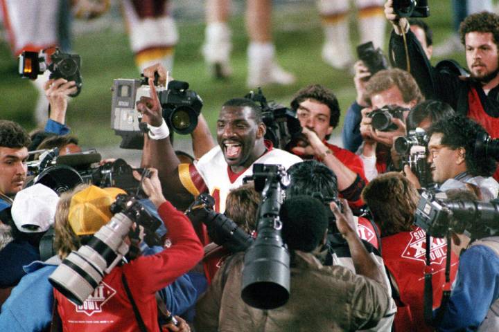 FILE - Washington Redskins quarterback Doug Williams is surrounded by members of the media afte ...