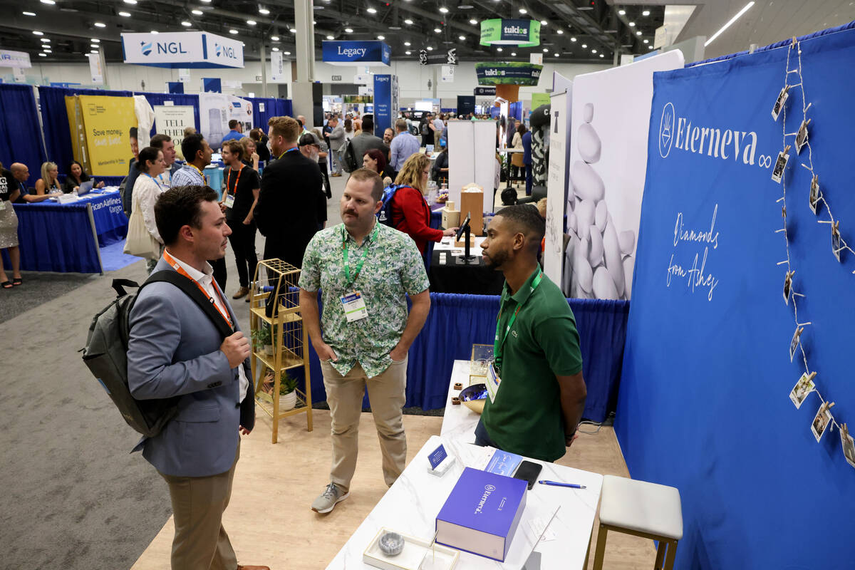 Garrett Ozar, center, and Ray Roberts, right, of Eterneva, talk to Branon Kincaid of Marinella ...