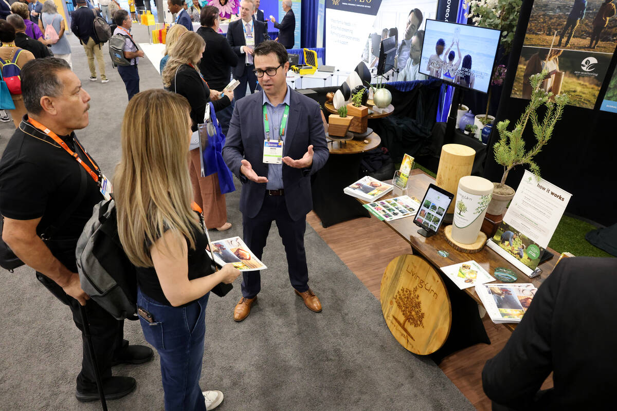 Mark Brewer of The Living Urn, right, talks to Mario Ruiz and Lorena Garcia of Garcia Mortuary ...