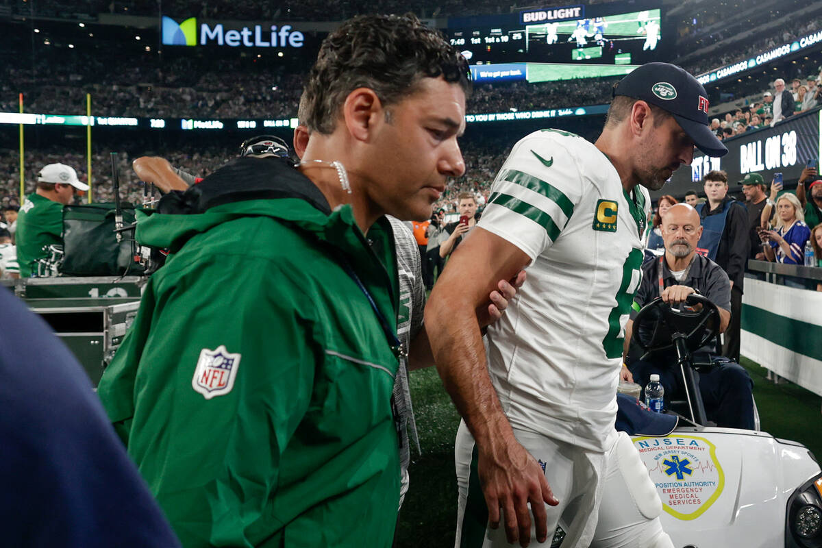 New York Jets quarterback Aaron Rodgers (8) is helped off the field during the first quarter of ...