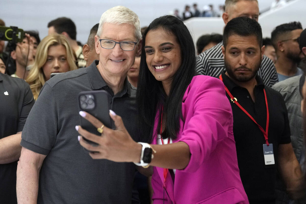 Apple CEO Tim Cook poses for a selfie with Indian badminton player P.V. Sindhu during an announ ...