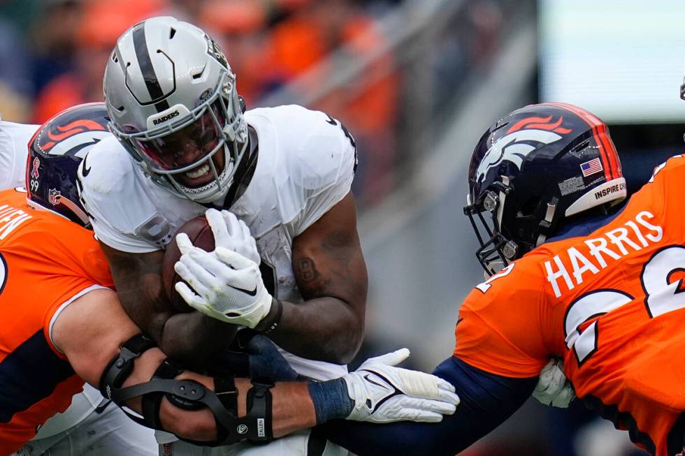 Las Vegas Raiders running back Josh Jacobs (8) rushes against Denver Broncos defensive end Zach ...