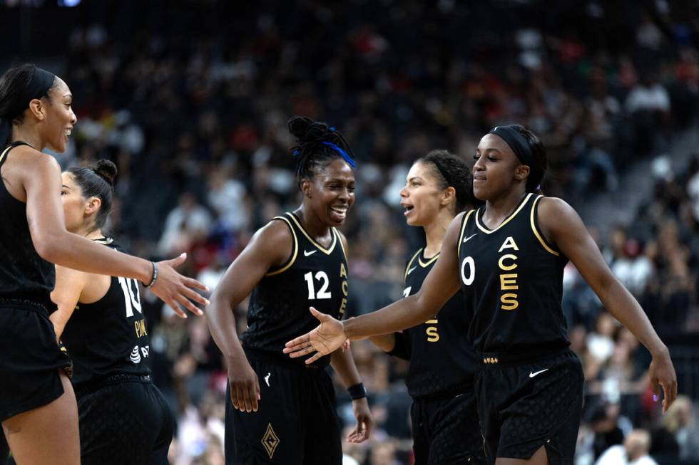 The Las Vegas Aces congratulate their guard Jackie Young (0) after being fouled by the Chicago ...