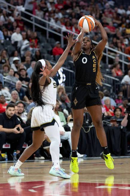 Las Vegas Aces guard Jackie Young (0) shoots against Chicago Sky guard Dana Evans, left, during ...