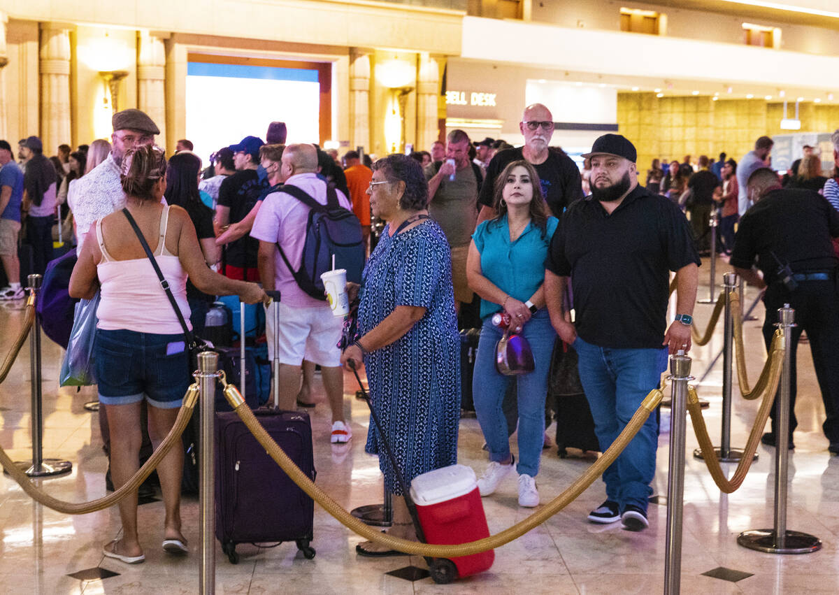 Hotel guests wait in line as they check in at Luxor hotel-casino, on Thursday, Sept. 14, 2023, ...