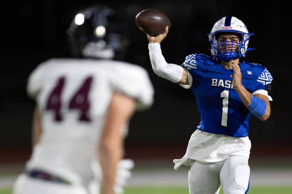 Basic quarterback Anthony Vega (1) throws the ball into play while Faith Lutheran’s Mitc ...