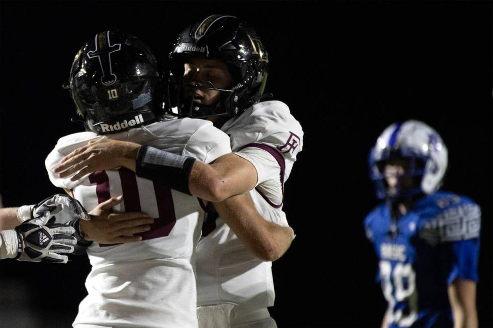 Faith Lutheran quarterback Garyt Odom (3) hugs quarterback Graham Radke (10) after he scored a ...