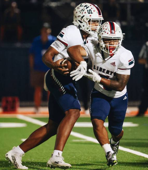 Liberty quarterback Tyrese Smith (11) pretends to pass the ball to running back Isaiah Lauofo ( ...