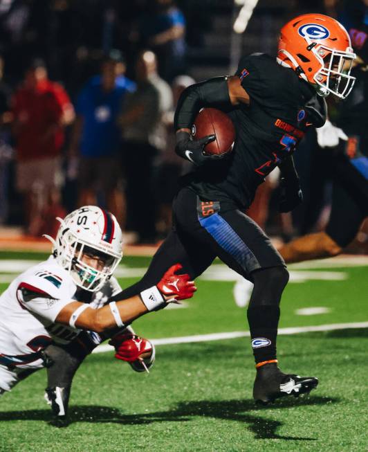 Bishop Gorman running back Devon Rice (3) runs the ball as he brushes off a Liberty player duri ...