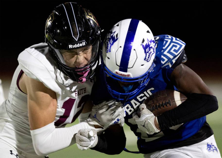 Faith Lutheran fast safety Gavin Day (12) pushes Basic wide receiver Zuri Whiters (23) out of b ...