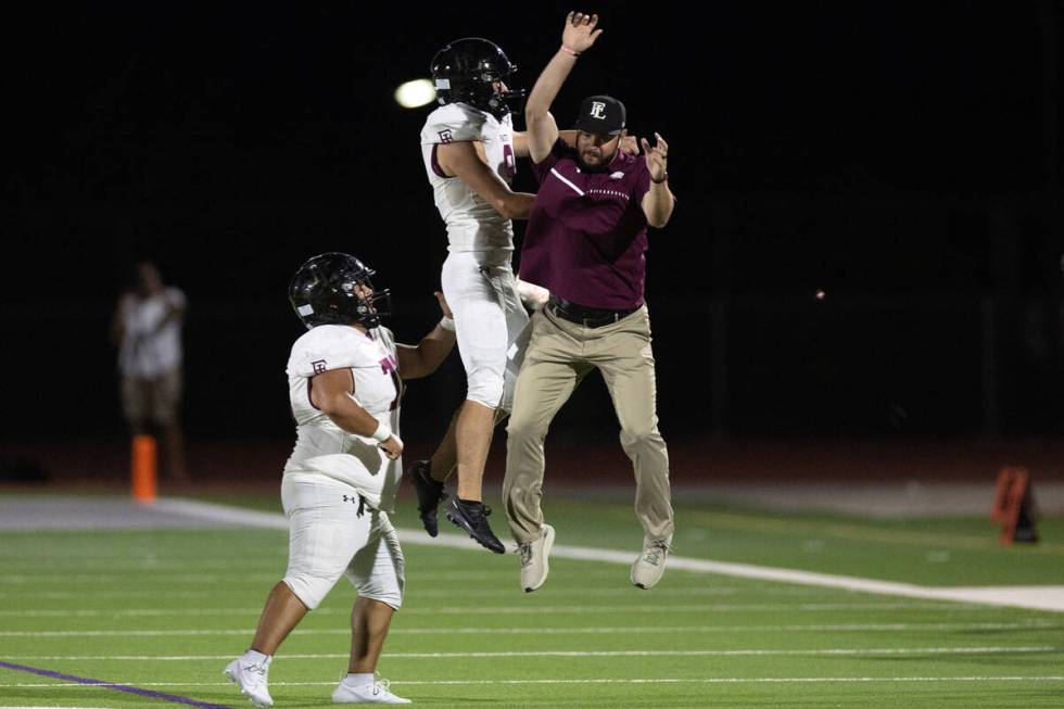 Faith Lutheran kicker Caden Chittenden (9) celebrates his 57-yard field goal with coach Nolan K ...