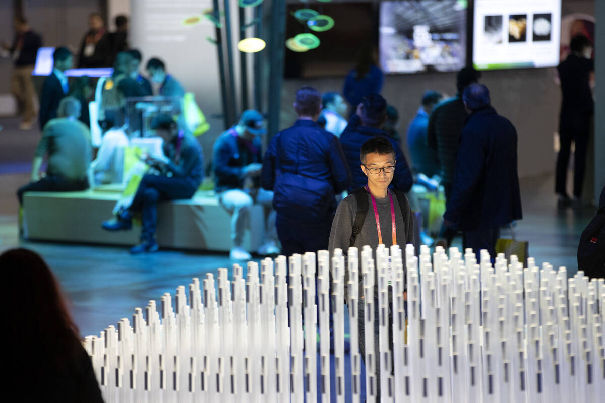 An attendee views a display of rechargeable lithium ion batteries at the Panasonic booth during ...