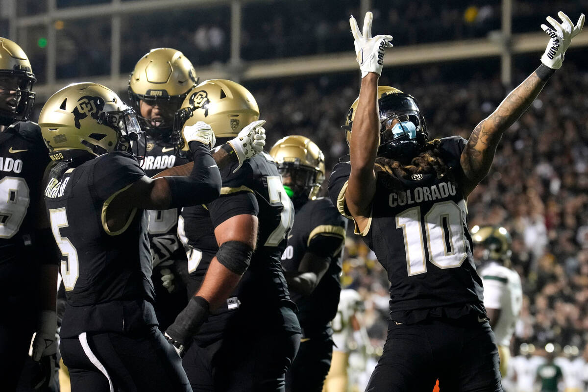 Colorado wide receiver Xavier Weaver, right, celebrates after catching a pass to complete a two ...