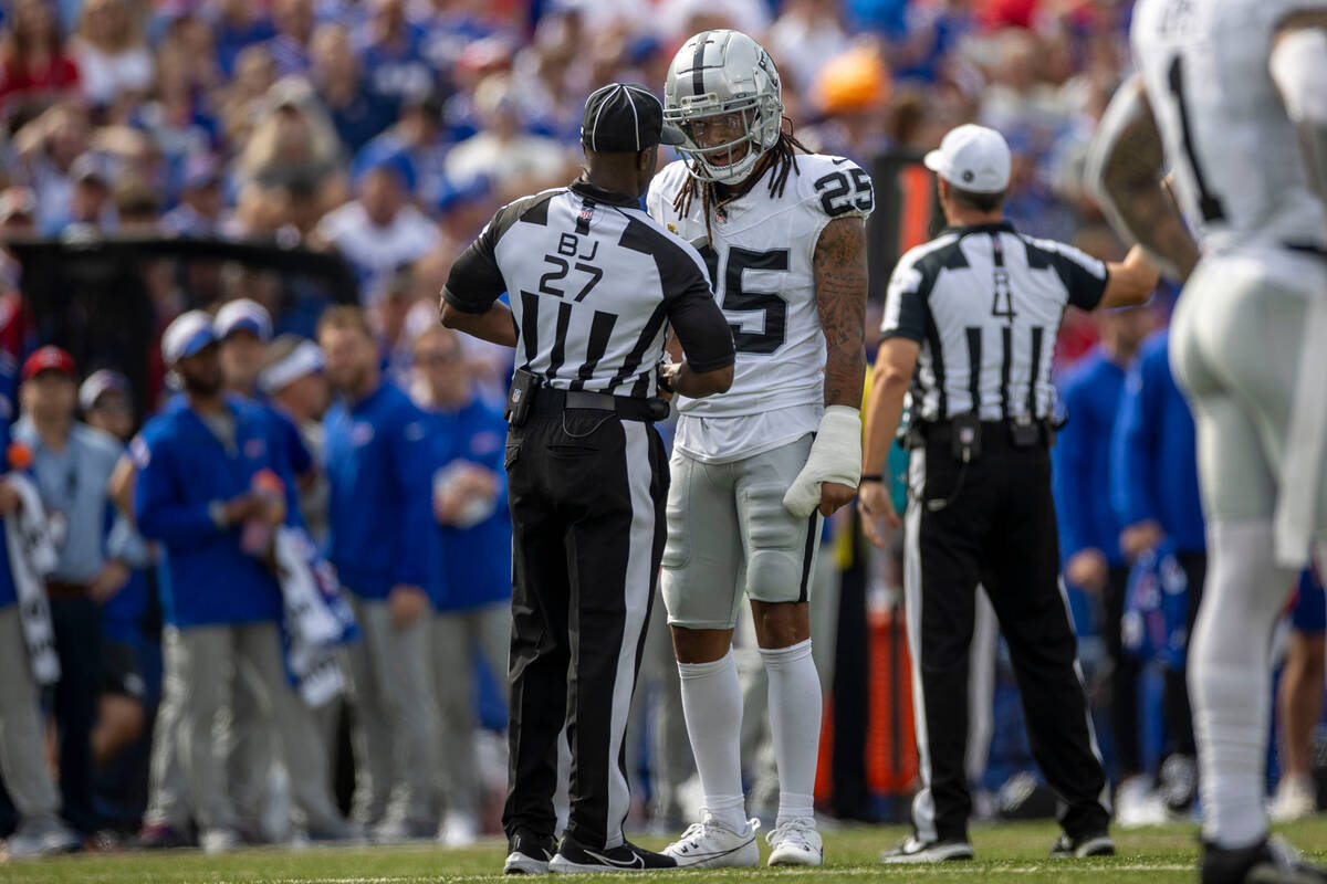 Raiders safety Tre'von Moehrig (25) speaks to field judge Ryan Dickson (25) after a penalty fla ...