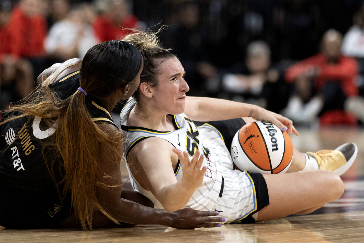 Las Vegas Aces guard Jackie Young (0) and Chicago Sky guard Marina Mabrey (4) struggle for the ...