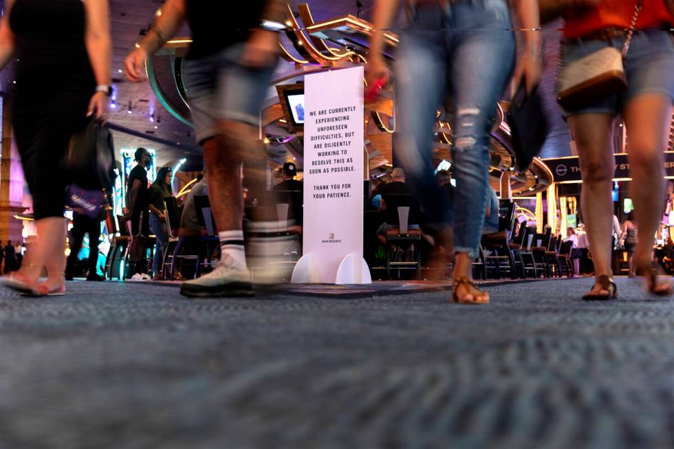 Guests walk through New York New York past a sign about MGM's "unforeseen difficulties&quo ...