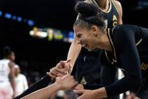 Las Vegas Aces forward Alysha Clark (7) helps forward A'ja Wilson, obscured at left, up from th ...