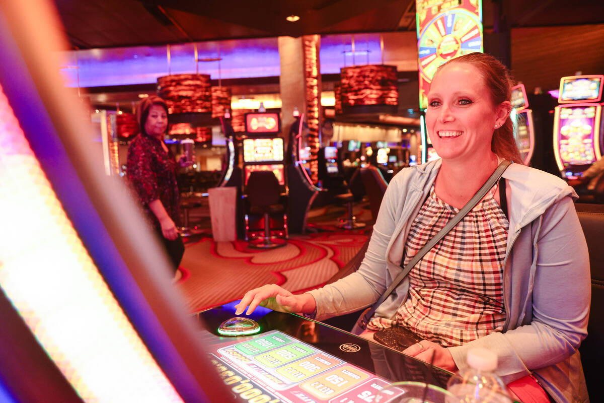 Candice Low, of Washington, plays the first Vegas NFL slot machine at the M Resort in Las Vegas ...